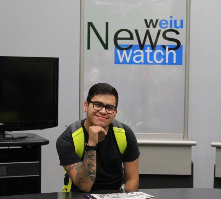 Editor-in-Chief, Ismael Cordova, sitting at the front desk of the WEIU Newswatch at Eastern Illinois University.