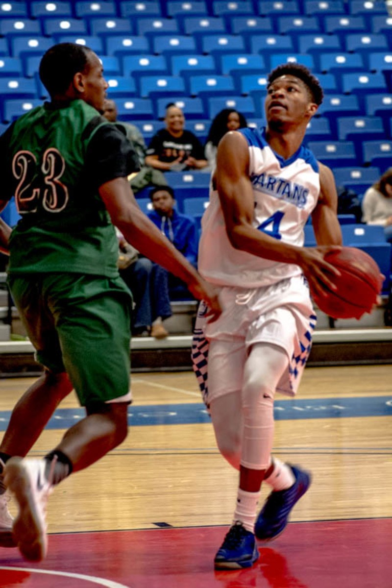 Chaquille Bennett drives to the hoop during the Spartans game against Oakton. The Spartans won 69-65.
