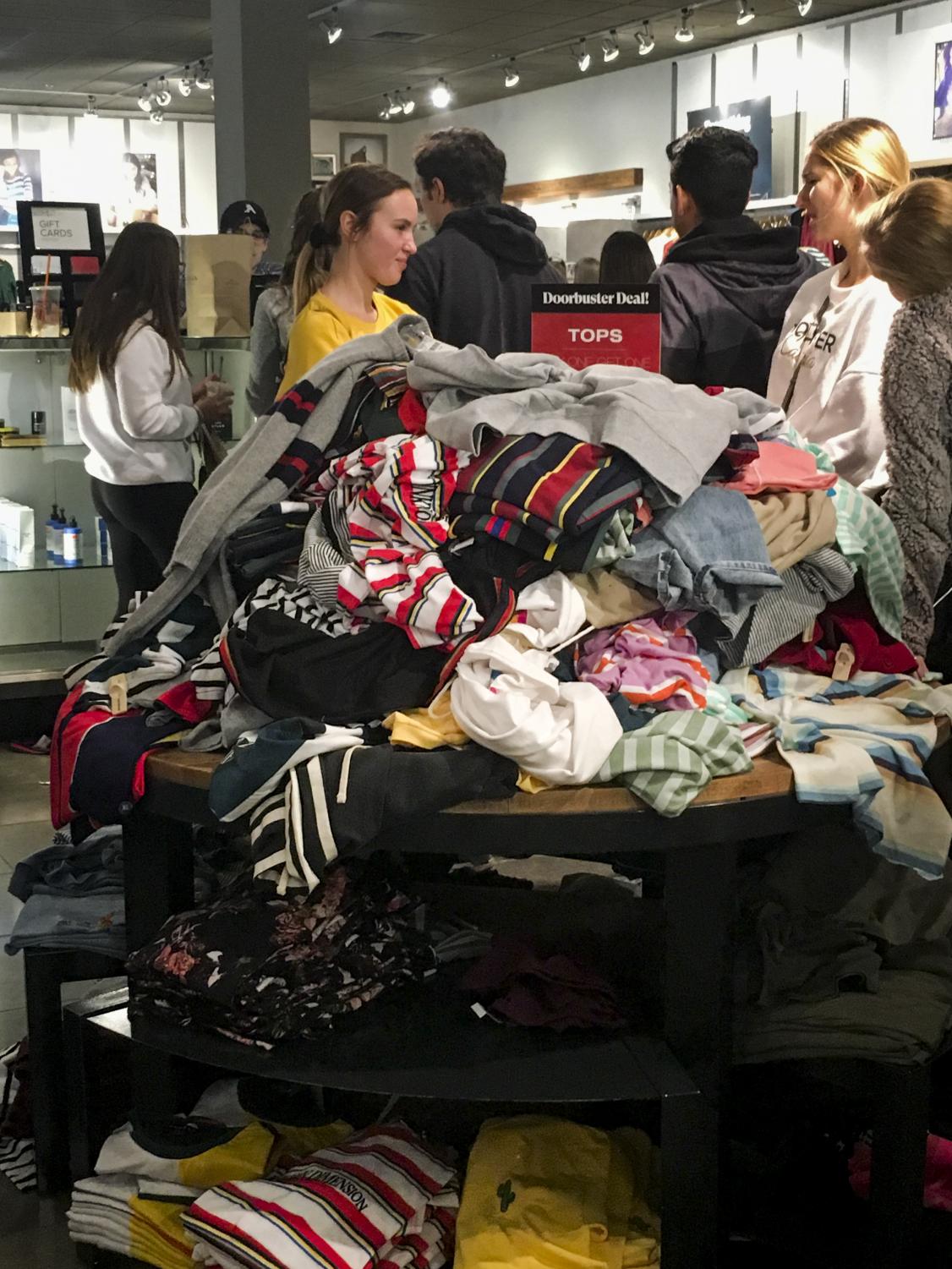 Shoppers fill up stores and rummage through clothes on Black Friday