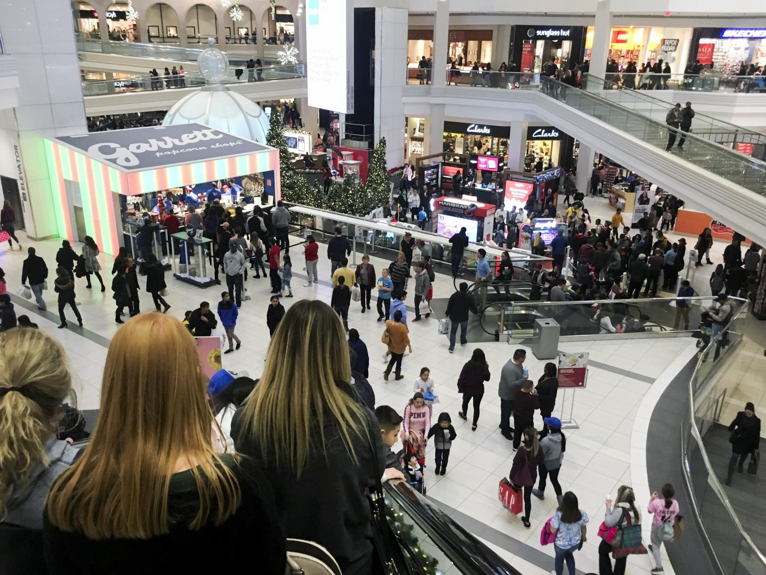 Shoppers fill up stores and rummage through clothes on Black Friday