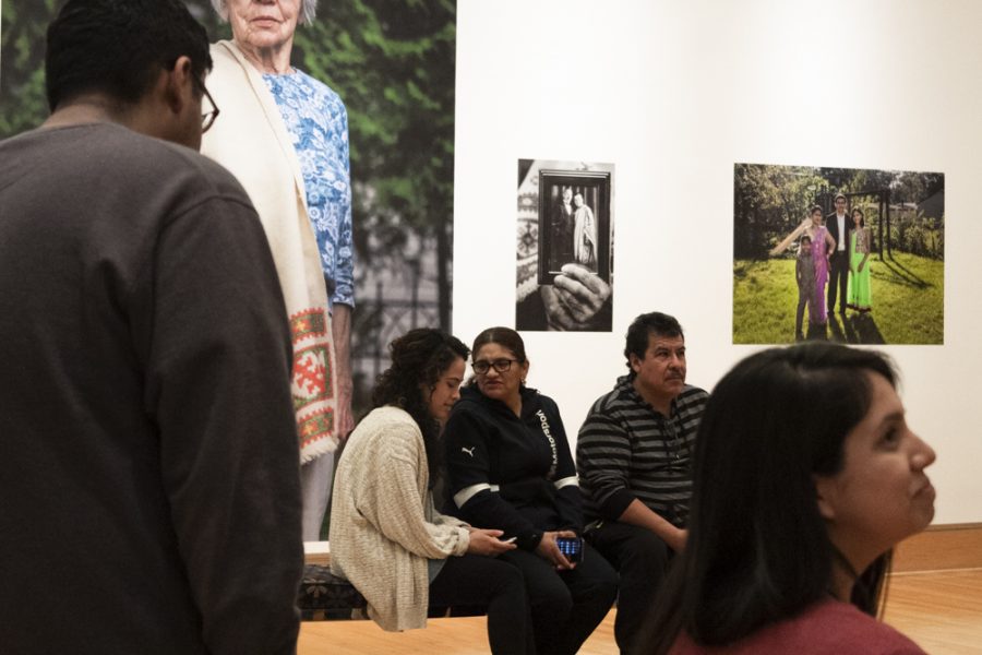 The Safety-Kleen Gallery gets a full house during a reception on its latest collection, Finding Home, on March 14. Photographer, Norma Santaolaya, sitting with her mother and father who was the subject of her photos featured in the show. 