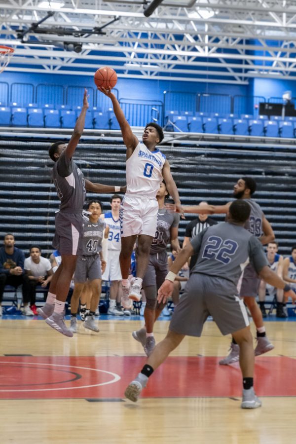 Elgin Community College mens basketball play a close, intense game against South Suburban College, winning 86-80 on Nov. 7. Julian Harvey leaps high with finger roll shot.