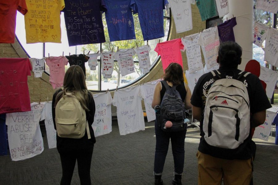 Students look at the clothesline project for Domestic Violence Awareness Month.