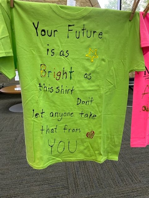 A t-shirt from the clothesline project reads, Your future is as bright as this shirt. Dont let anyone take that from you.