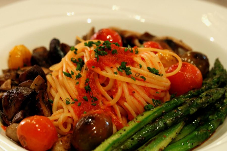 Vegetarian pasta with tomato capers, mushrooms, asparagus, and basil coulis. 