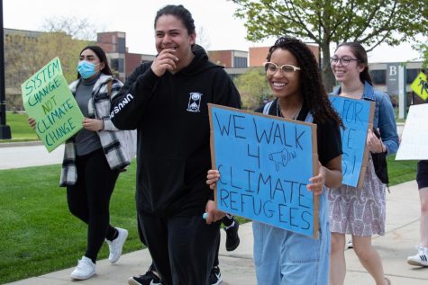 Student Leader Alexia Smith at the Climate Refugee walk, holding a sign that says We walk 4 climate refugees.