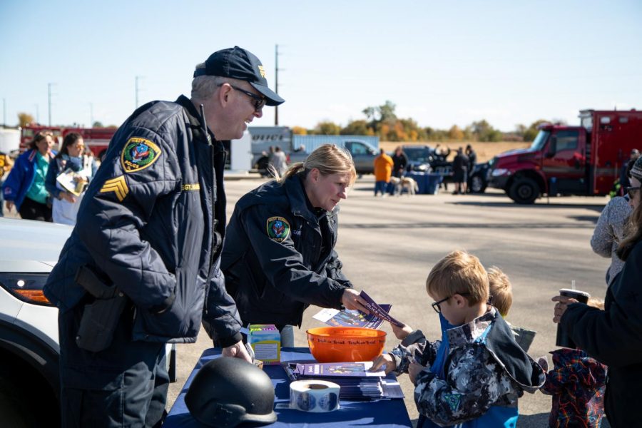 West Dundee Police Sgt. Daniel Haines, left, and School Resource Officer Kate McCarthy hand out coloring books at the ECC Center for Emergency Services Open-House Event in Burlington on Saturday, Oct. 15, 2022. 