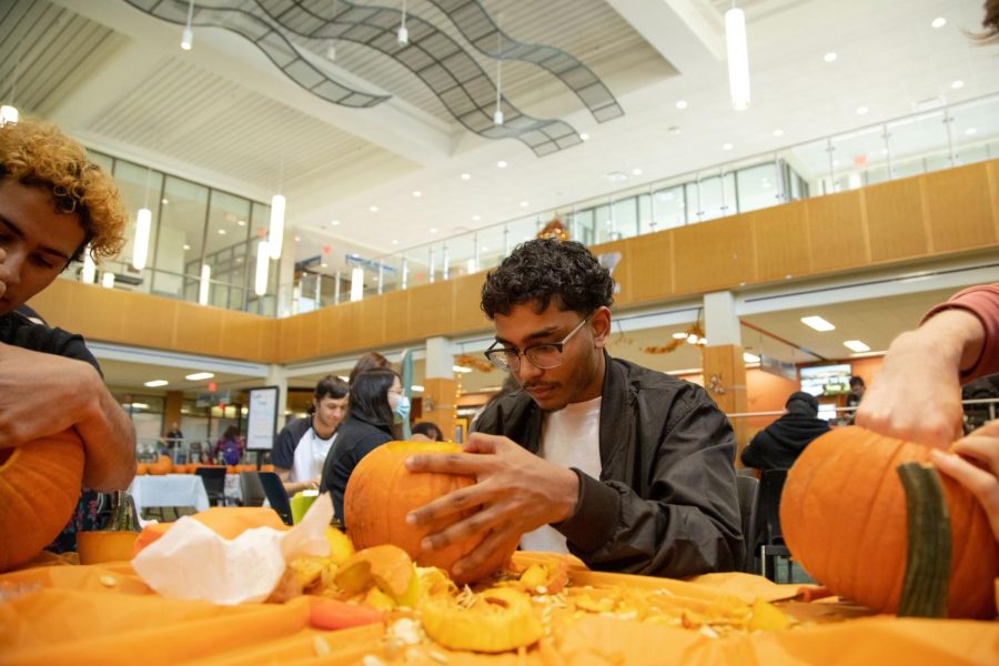 Second-year student Fazal Quadri carves a pumpkin at ECCs Fall Fest on Wednesday, Oct. 5, 2022. 
