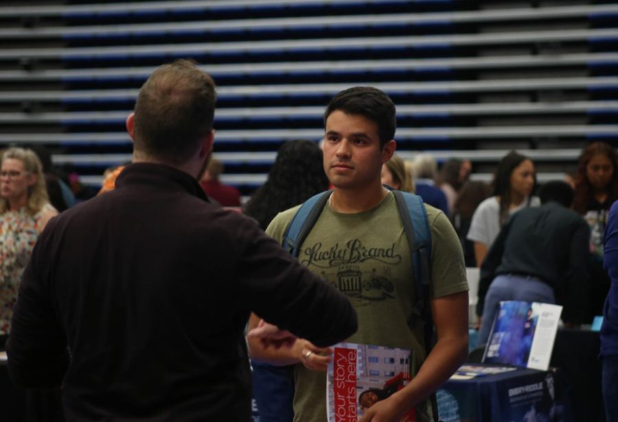 Marco Adrianzen talks to a representative from Lewis University at college night in Building J on Wednesday, Oct. 12, 2022. 
