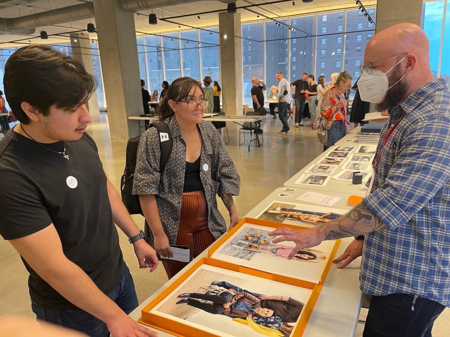 ECC Students Kevin Vilchis, left, and Madison Schneider look at a photographers work during the Filter Photo Festivals portfolio walk on Saturday, Sept. 16, 2022. 