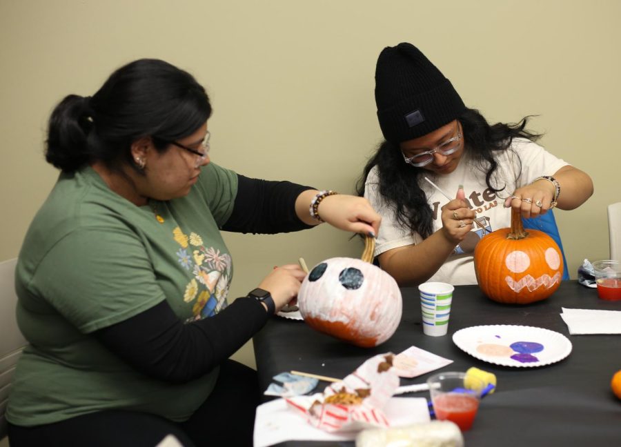First-year-students Juana Solis (left) and Paula Velasquez (right) paint pumpkins at the event(CHANGE LATER) on Oct. 20, 2022.