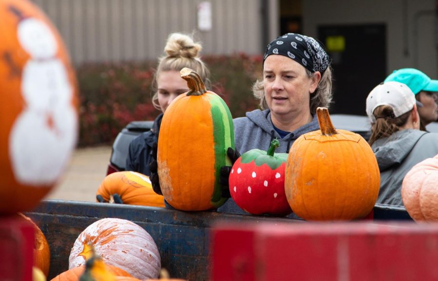 Volunteer Megan Bockenhauer of St. Charles places a pumpkin on top of the dumpster during the Green Your Halloween pumpkin composting event at the St. Charles Public Works Facility in St. Charles on Saturday Nov. 5, 2022. Volunteers displayed pumpkins that they found cool or interesting. 