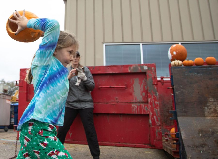 Evelyn Rice, 9, of Geneva throws a pumpkin into a dumpster during the Green Your Halloween pumpkin composting event at the St. Charles Public Works Facility in St. Charles on Saturday Nov. 5, 2022.  