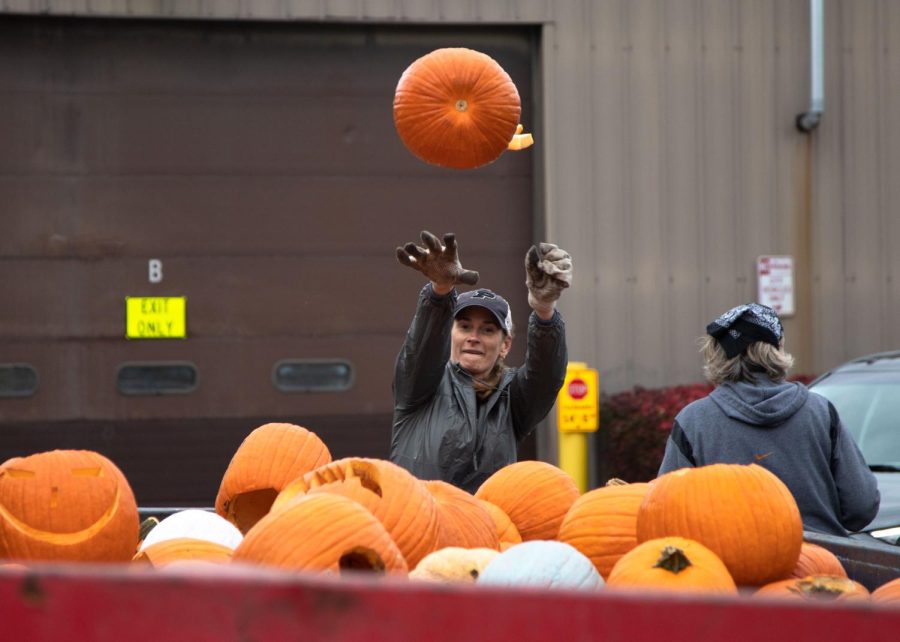 Volunteer Heather Goudreau of St. Charles throws a pumpkin in the dumpster during the Green Your Halloween pumpkin composting event at the St. Charles Public Works Facility in St. Charles on Saturday Nov. 5, 2022.  
