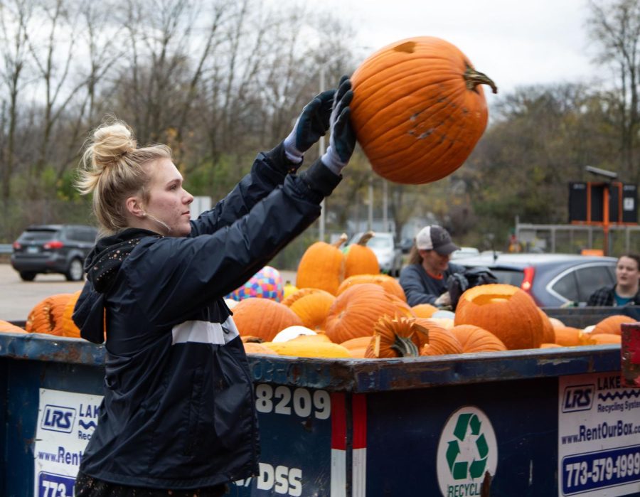 Volunteer Lauren Benson, 17, of Geneva throws a pumpkin into a dumpster at the Green Your Halloween pumpkin composting event at the St. Charles Public Works Facility in St. Charles on Saturday Nov. 5, 2022.  