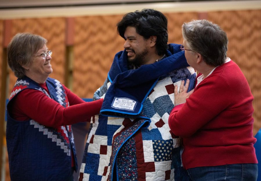 Quilts of Valor volunteers, Naomi Payne, left, and Carol Earsley, right, present Navy veteran and first year student Manny Vazquez with a quilt during the Veterans Day Celebration in the Jobe Lounge at ECC on Friday Nov. 11, 2022.  