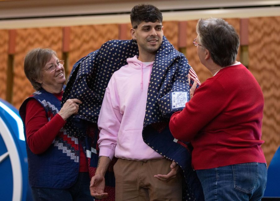 Quilts of Valor volunteers, Naomi Payne, left, and Carol Earsley, right, present Marine Corps veteran and first year student Eric A. Macias with a quilt during the Veterans Day Celebration in the Jobe Lounge at ECC on Friday Nov. 11, 2022.  
