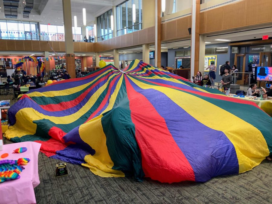 The outside of a rainbow parachute billows  while students are inside at Recess Day on Nov. 15. Here, a common elementary gymnasium activity is used to help students relive their youthful days.