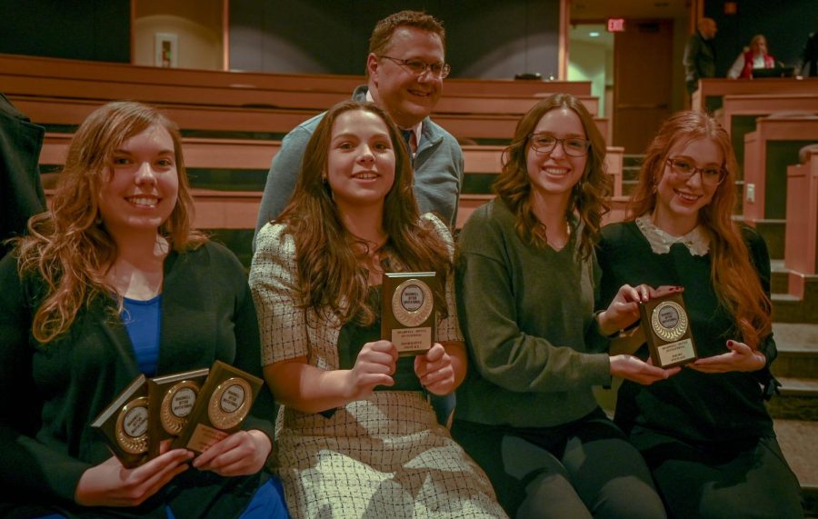 ECC speech team members (front row, left to right) include Aleah Janae, Zuzanna Lapa, Hannah Carpenter and volunteer coach Madeline Ford, along with coach Tim Anderson in the back. 