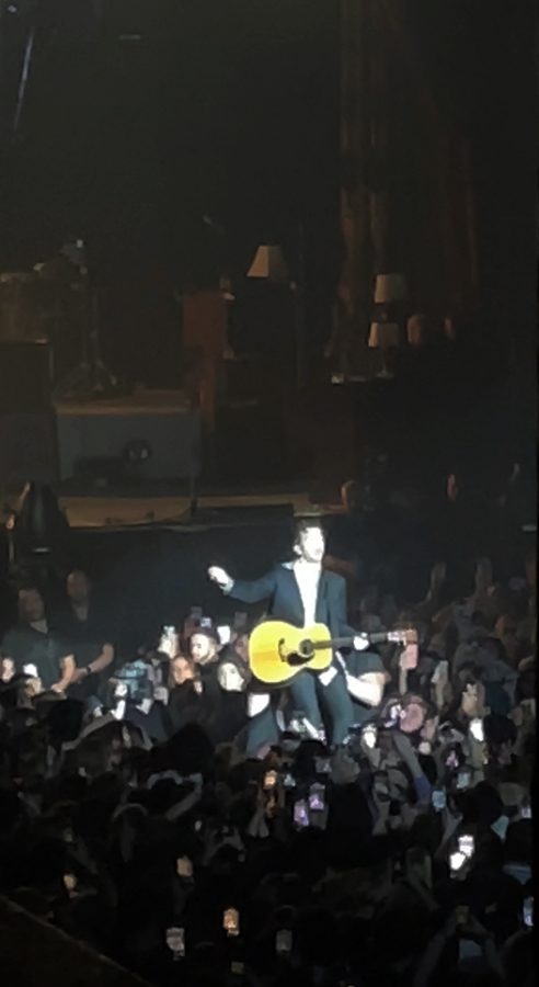 Matty Healy held up by security guards, so he can perform the concerts final song. 