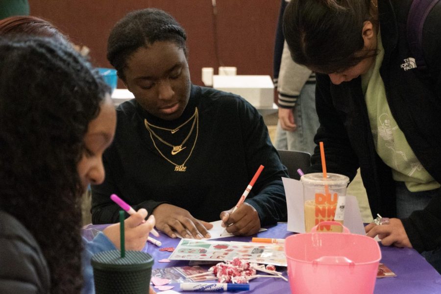 First-year students Naomi Alemu (left) and Imani Sykes (center) create Valentines Day cards for seniors in the Jobe Lounge on Feb. 7, 2023. 