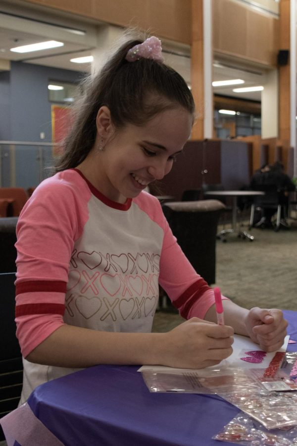 Smiles for Seniors event organizer Nadia Shaaban writes a message on a valentine in the Jobe Lounge on Feb. 7, 2023.