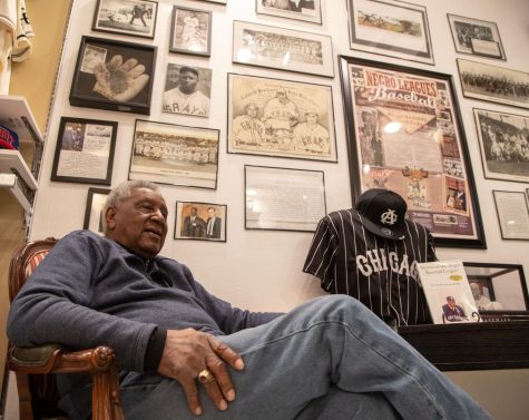 Dennis Biddle poses for a photo in front his Wall of Negro League History in his store in the Mayfair Mall in Wauwatosa, Wisconsin on Monday Dec. 5, 2022.
