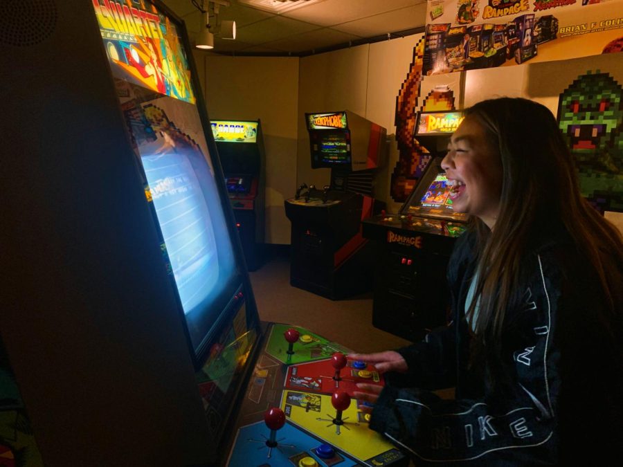 Megan Castillo laughs as she plays an arcade game at the Underground Retrocade. 