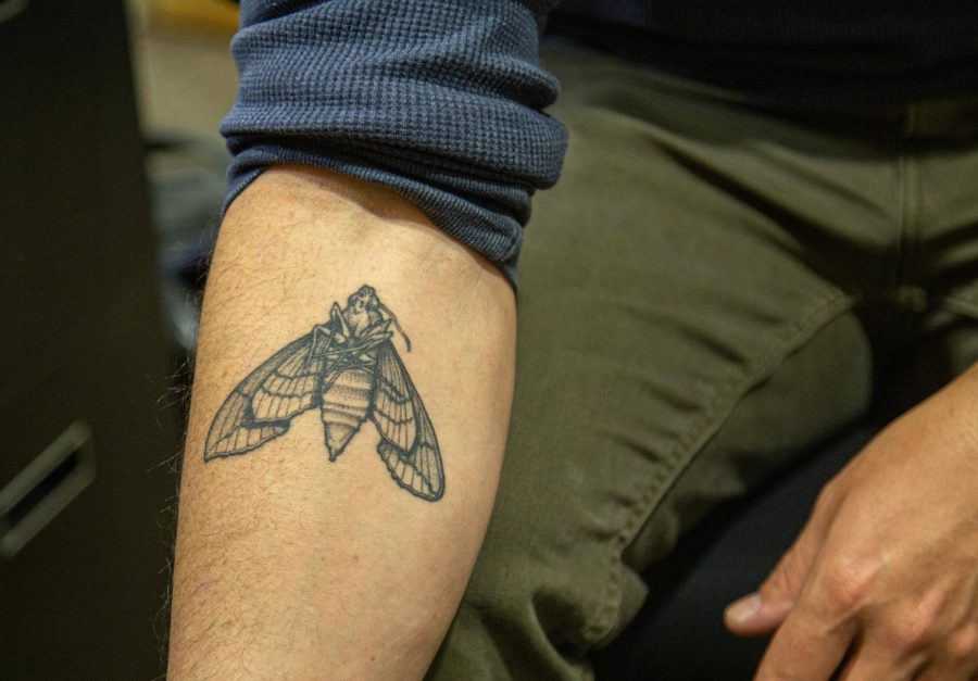 Professor of Photography Travis Linville shows off his moth tattoo on Feb. 22, 2023. The moth tattooed on his inner forearm is from a photograph Linville created entitled Lifespan, which embodies the ideology of carpe diem (seize the day).