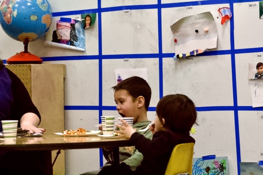 Some kids are working with the Early Development Staff and Students, while eating. Picture was taken on Mar. 3, 2023.