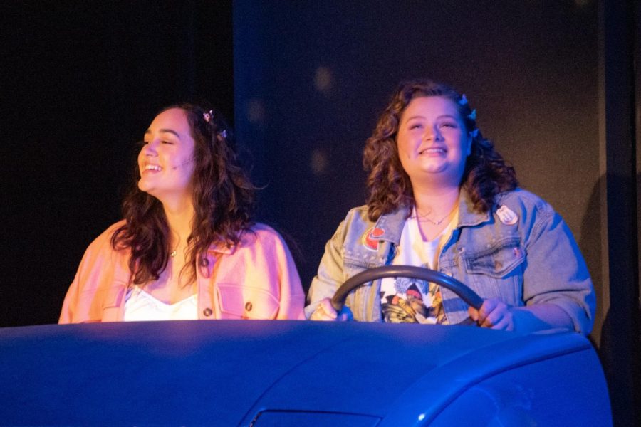 Sam (left), played by Gabrielle Urbina, and Kelly (right), played by Olivia Litton, sing together behind the wheel in the Spartan Auditorium on Feb. 23, 2023. 