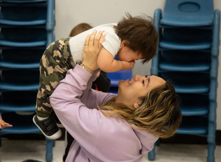Briana Calandria lifts up a toddler at ECCs Early Childhood Lab School on March 2, 2023. 