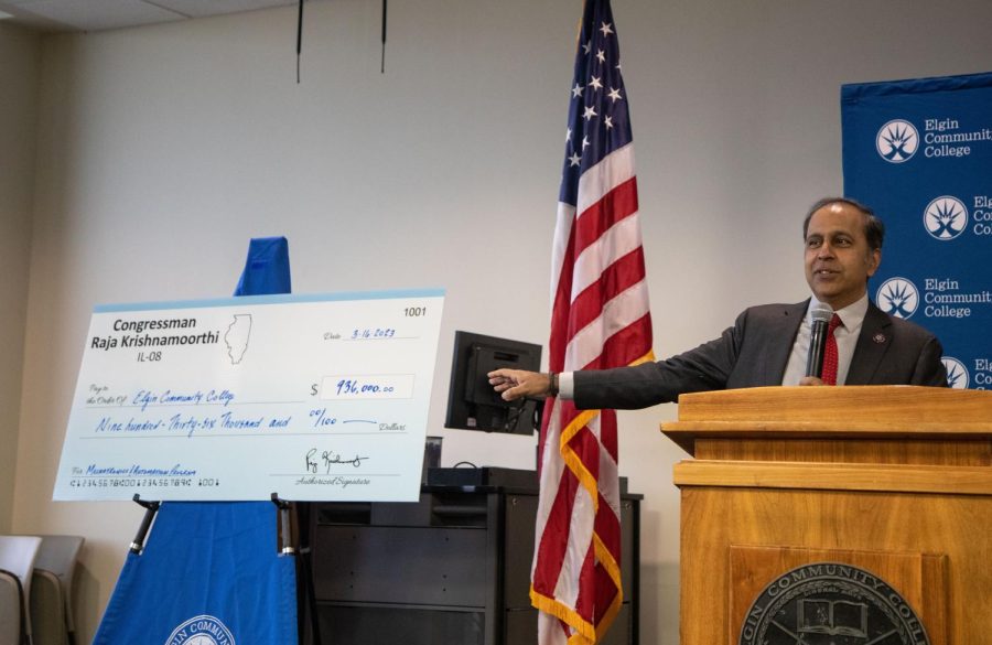 Rep. Raja Krishnamoorthi points at a large check that he presented to ECC during a breakfast for local leaders in manufacturing at ECC on Thursday, March 16, 2023.