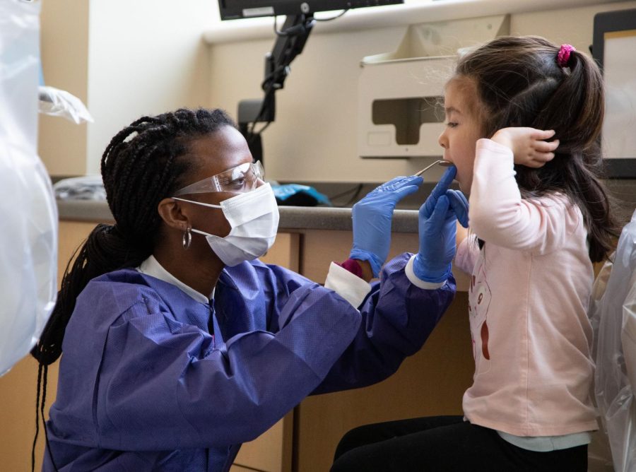 Third-year student Shamyri Beal uses a dental mirror to look in the mouth of an ECL student at ECCs dental clinic on Wednesday, March 8, 2023. 