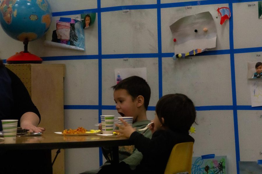 Some kids are working with the Early Development Staff and Students, while eating. Picture was taken on Mar. 2, 2023.