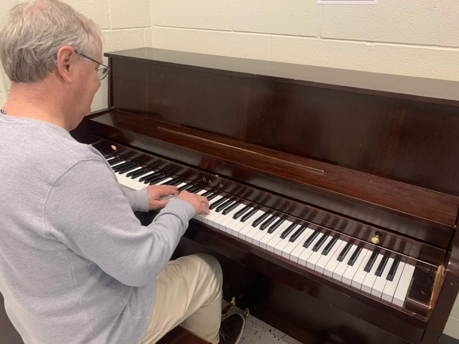 Musics of the World Professor Jeff Hunt plays the piano in his classroom.