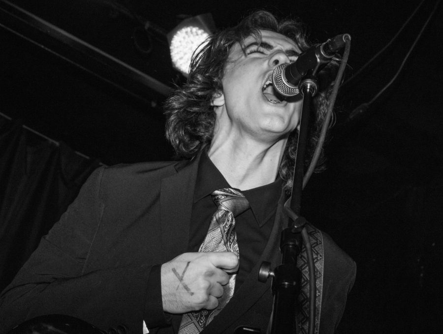 Lead singer and guitarist of Moon Rules Apply, Andre Holman, screams into the microphone at the bands album release party in Chicago on March 3, 2023.