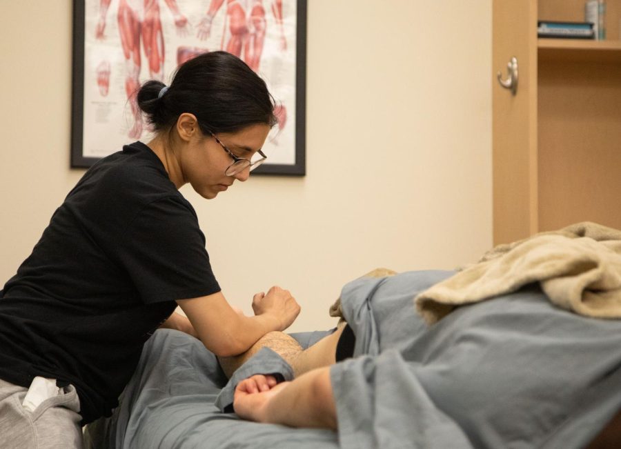 Emily Solorio practices massage techniques during a Massage Therapy Class in Building A on Thursday, April 13, 2023
