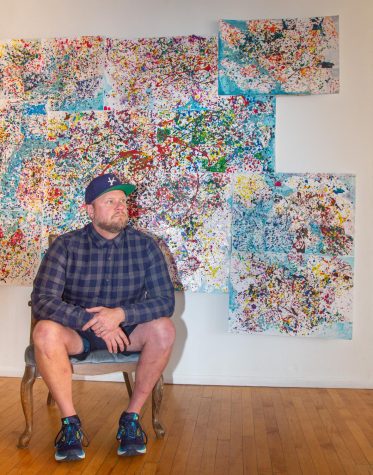 Co-Founder and Co-Executive Director of Side Street Studio Arts Tanner Melvin sits in front of an art piece and stares off into the distance at Side Street Studio Arts on May 9, 2023.