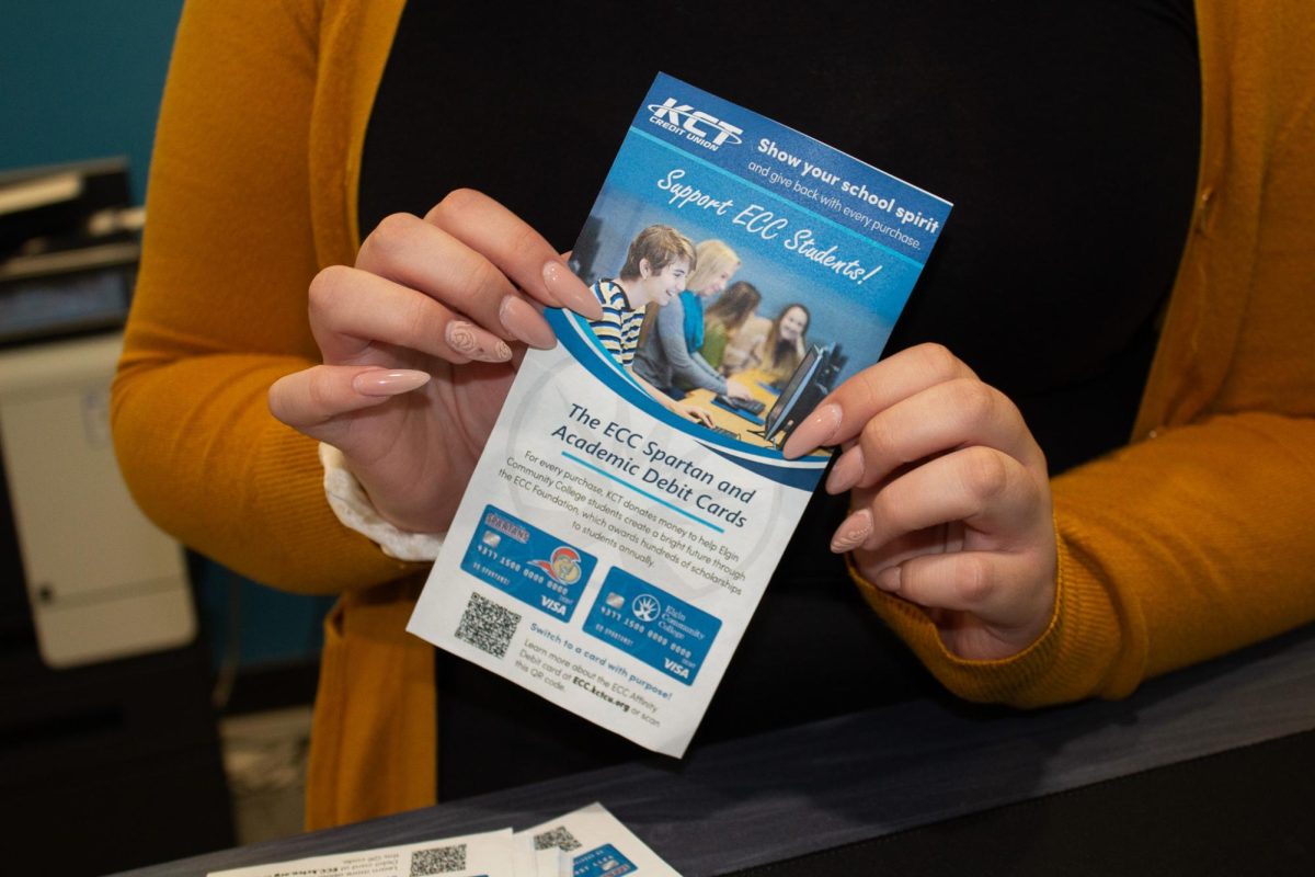 Member Service Specialist Gabriela Rango   holds up a flyer advertising Affinity Debit Cards at the Center for Financial Empowerment and Wellness on Sept. 26, 2023. 