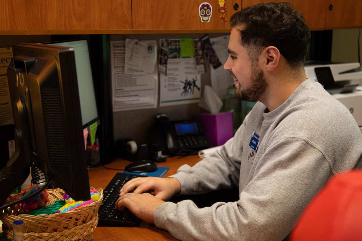 Student Success Coach Victor Brito sits at his desk and types on Sept. 13, 2023.