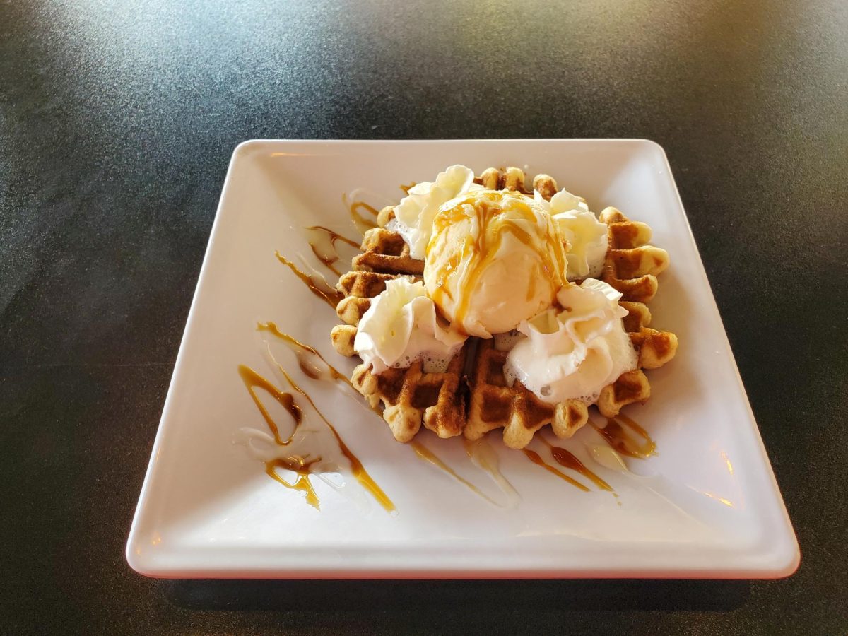 A plate of vanilla ice cream sits on top of a crispy waffle from Coffee Haus sits on a countertop on Oct. 25, 2023.