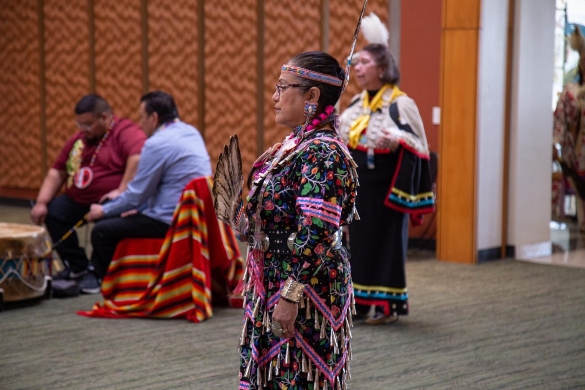 A female member of the Black Hawk Performance Company gets ready to partake in the womens traditional dance at the  Black Hawk Dance Troupe event in the Jobe Lounge on Oct. 11, 2023.