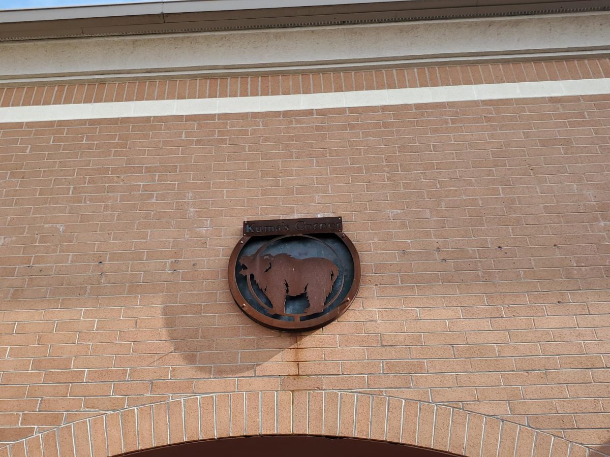 Kumas Corner 1570 E. Golf Rd, Schaumburg, IL 60173. November 7, 2023. This is the restaurants logo resting in a brick wall above the entrance. 
