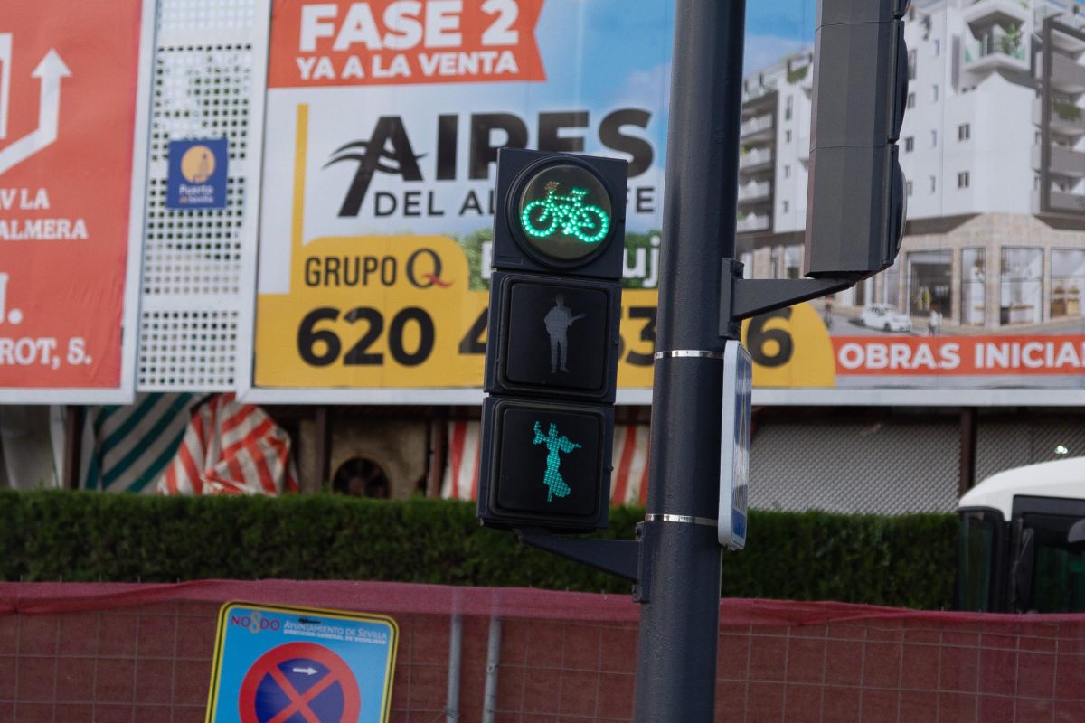 The city of Seville changes nearby pedestrian lights to reflect a flamenca dancer and a man with a guitar during la Feria.