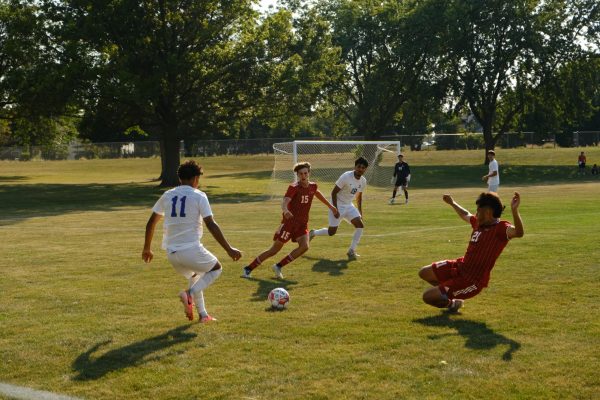 Player #11 from our school’s soccer team moves the ball upfield, evading a slide tackle from Waubonsee College's Player #21 during the game at Spartan Athletic’s Field on September 17. The teams battled intensely near the goal, with both sides showing strong defensive maneuvers.