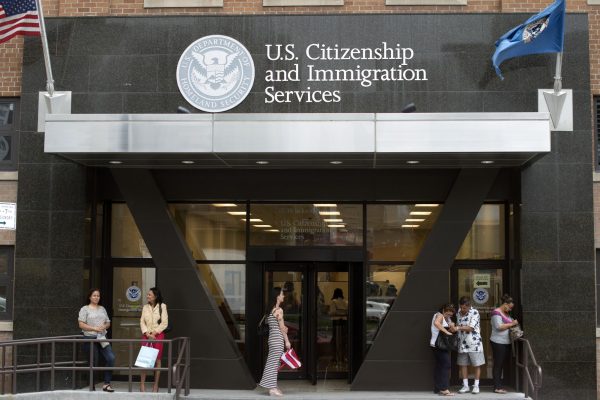 People stand on the steps of the U.S. Citizenship and Immigration Services offices in New York, August 15, 2012. REUTERS/Keith Bedford