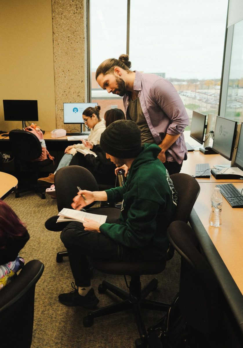Dr. Kellen Bolt, an English professor, provides one-on-one guidance to a student, exemplifying personalized support during a session in the computer lab.