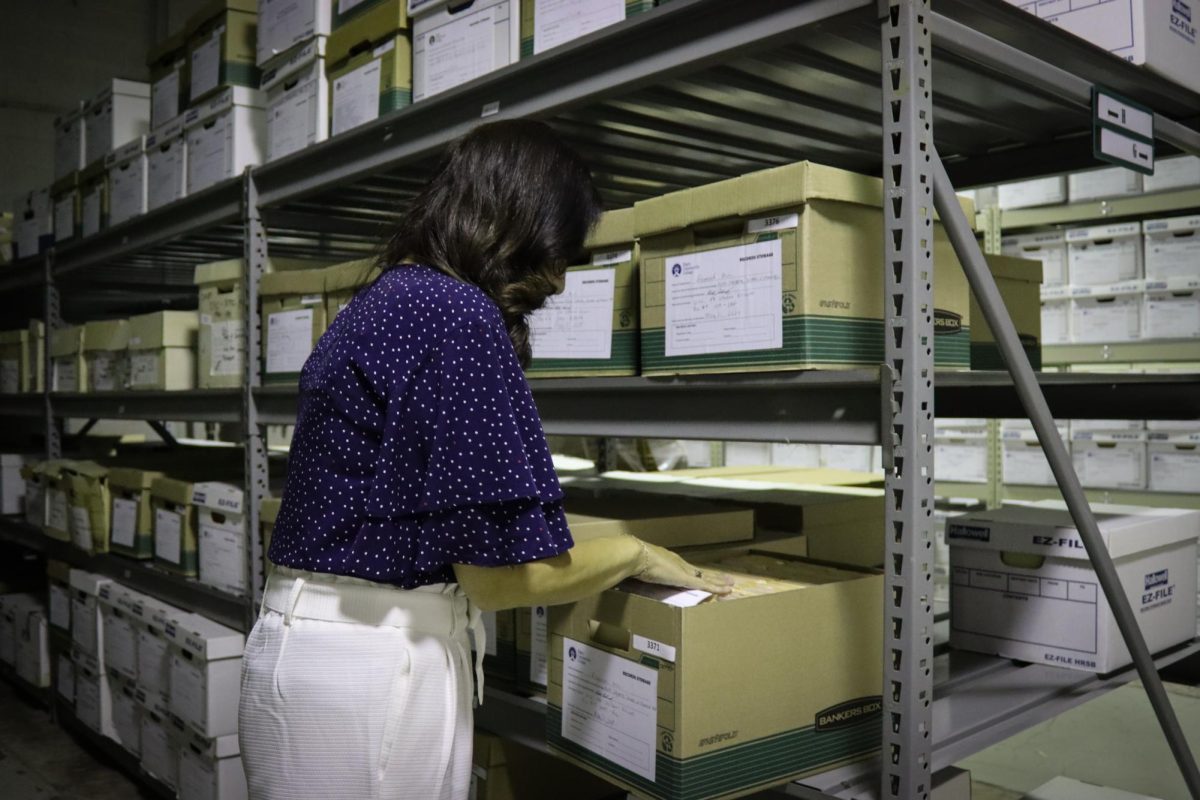 Gema Macklin, Director of Logistics, Records, and Asset Management, sorts through files in the records retention room.