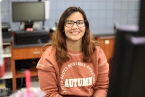 Cashier Jessica Severing in an orange-brown sweatshirt.